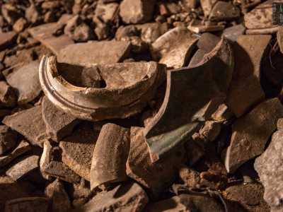 Per terra troviamo vecchie bottiglie e pezzi di vasellame ceramico...